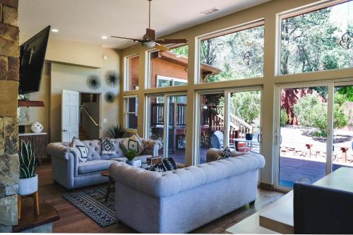 a living room with couches and a large window at ULTIMATE Mountain Escape with Pool & Hot Tub & Firepit in Sedona