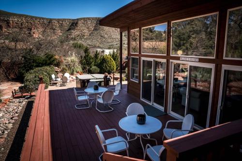a deck with tables and chairs and a mountain at ULTIMATE Mountain Escape with Pool & Hot Tub & Firepit in Sedona