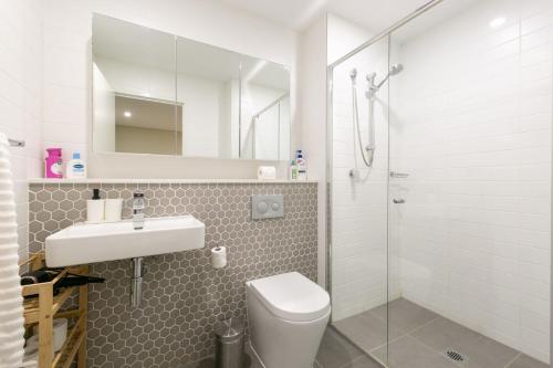 y baño con aseo, lavabo y ducha. en Comfortable apartment, near Parramatta CBD!, en Merrylands