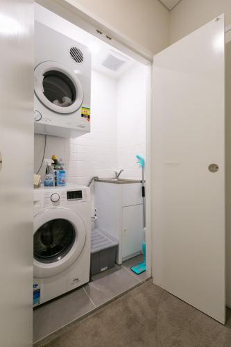 y baño pequeño con lavadora y secadora. en Comfortable apartment, near Parramatta CBD!, en Merrylands