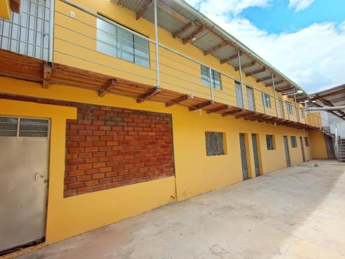 een leeg schoolgebouw met gele verf en een bakstenen muur bij OCALA HOUSE 4.0 in Huánuco