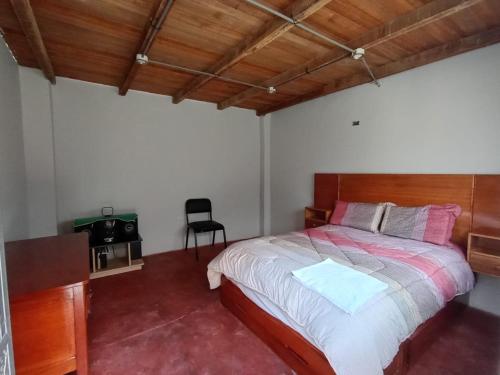 1 dormitorio con 1 cama y 1 silla en OCALA HOUSE 4.0, en Huánuco