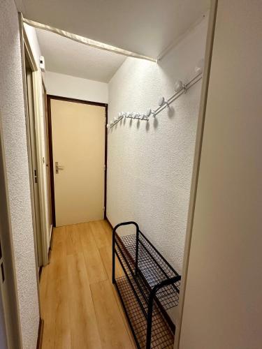 - un couloir avec un lit dans une chambre avec une porte dans l'établissement Studio Pablotin du Queyras, à Abriès