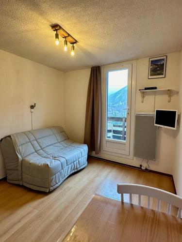 a bedroom with a bed and a large window at Studio Pablotin du Queyras in Abriès