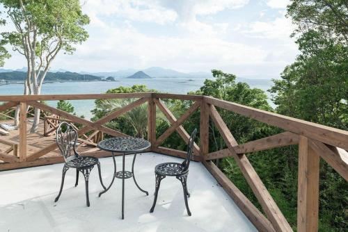 2 krzesła i stół na balkonie z widokiem na wodę w obiekcie LaVilla - Vacation STAY 27368v w mieście Nobotate
