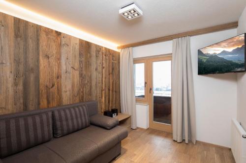 a living room with a couch and a large window at Familienappartement Seenland in Reith im Alpbachtal