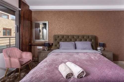 um quarto com uma cama grande com duas toalhas em LINA'S LUXURY APARTMENT em Loutraki