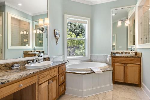 a bathroom with two sinks and a large mirror at Peaceful Country Charm with Private Pool in Dripping Springs