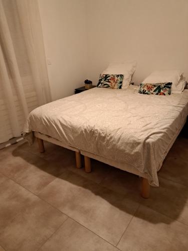 uma cama com duas almofadas num quarto em Maison JO 2024 Clamart em Clamart