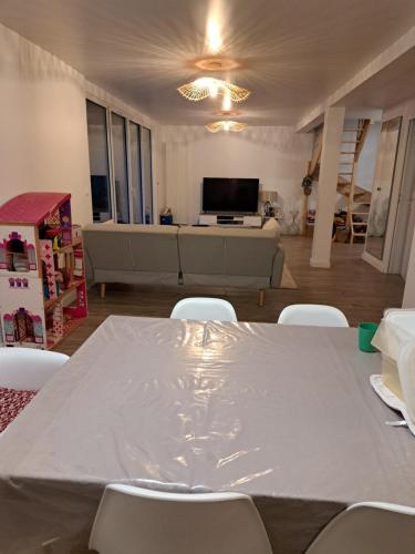 uma sala de estar com uma mesa branca e cadeiras em Maison JO 2024 Clamart em Clamart