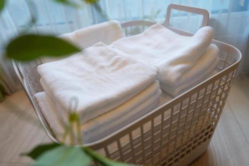 a basket filled with white towels in a bathroom at Mondomio Sapporo Minamisanjo Dori - Vacation STAY 16334 in Sapporo