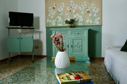 una sala de estar con un jarrón de flores sobre una mesa en appartamento la Bastia fra il lago di Garda e Brescia città, en Nuvolento