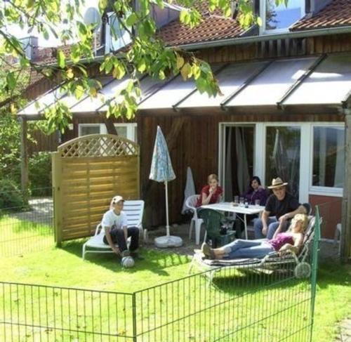 un grupo de personas sentadas en sillas en un patio en Ferienhäuser Schlossberg mit zwei sep Schlafräumen, kostenlosem w-lan und neuer Hausausstattung - b48525 en Zandt