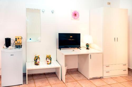 a room with a desk with a tv and a computer at Hotel Fernanda in Letojanni