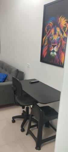 een bureau in een kamer met een schilderij van een leeuw bij Pousada da Vila in Araçariguama
