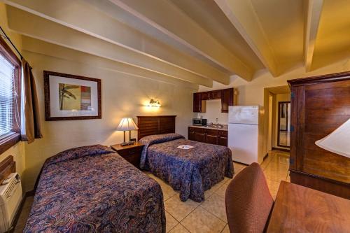 a hotel room with two beds and a refrigerator at Aladdin Motel By OYO Merritt Island in Merritt Island