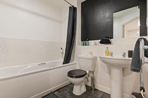 a white bathroom with a toilet and a sink at City Gate in Birmingham