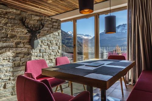 a dining room with a table and pink chairs at Ferienwohnungen direkt an der Skiabfahrt und MTB-Trails - b57507 in Sölden