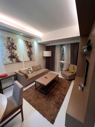 - un salon avec un canapé et une table dans l'établissement Monarch Suites at Padgett Cebu w/ pool near Ayala, à Cebu