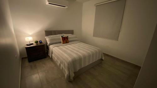 Habitación pequeña con cama con almohada. en Casa Orillia's Del Mar, en Isabela