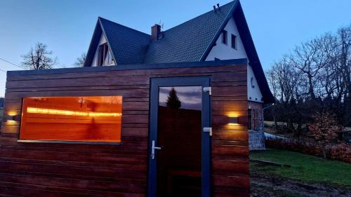 a tiny house with a large door in a yard at Chata w Stołowych in Łęzyce