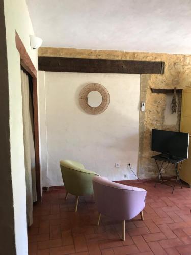un salon avec deux chaises et une télévision dans l'établissement Chambre Thym Mas Bel Esperance, à Saint-André-dʼOlérargues