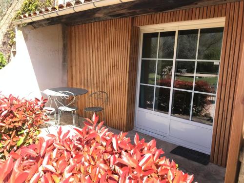 d'une terrasse avec une table et des chaises à côté d'une porte. dans l'établissement Chambre Thym Mas Bel Esperance, à Saint-André-dʼOlérargues