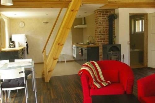sala de estar con sofá rojo y cocina en Ferienhaus in Gajwka mit Grill, Terrasse und Garten, en Gajowka