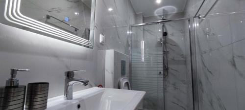 a white bathroom with a sink and a shower at Lusso di Campiello in Corfu Town