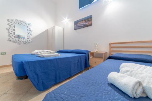 2 posti letto in una camera con lenzuola e asciugamani blu di Casa Vacanza Pamela ad Acquarica del Capo