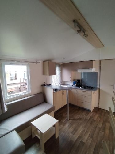 a small kitchen with a couch and a table at Mobil-Home 6 personnes avec TV et clim N' B025 in Boofzheim