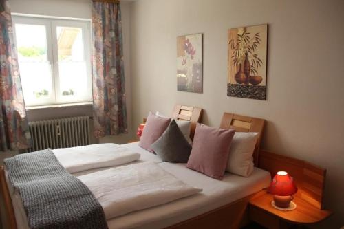 Schlafzimmer mit einem Bett mit weißer Bettwäsche und einem Fenster in der Unterkunft Ferienhaus in Zandt mit Grill und Garten in Zandt
