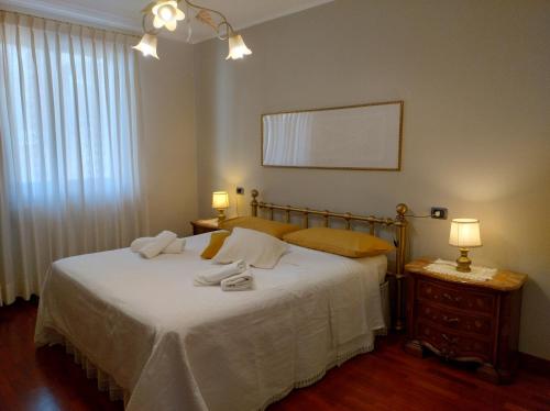 1 dormitorio con 1 cama con sábanas blancas y 2 lámparas en Casa JaRi, en San Giovanni Rotondo