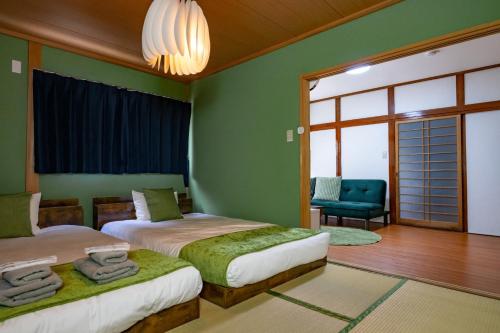 duas camas num quarto com paredes verdes em Satorie Beppu - Vacation STAY 19669v em Beppu