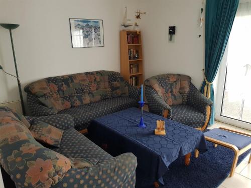a living room with two couches and a table at Ferienhaus in Neßmersiel mit Großer Terrasse in Dornum