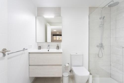 een witte badkamer met een toilet en een douche bij Isla de Sol in El Médano