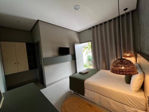 um quarto com uma cama e uma grande janela em Pousada Vila da Mata em Canaã dos Carajás