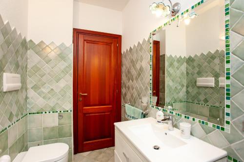 a bathroom with a sink and a toilet and a mirror at Villa Coclea con piscina in San Teodoro
