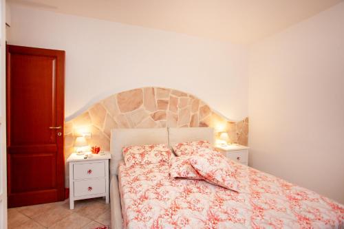 a bedroom with a bed and two night stands at Villa Coclea con piscina in San Teodoro