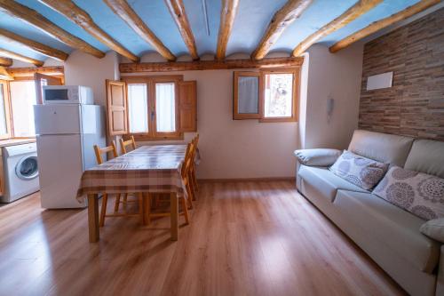 uma cozinha e sala de jantar com uma mesa e um sofá em Apartamentos la Rambla Callizo em Montalbán