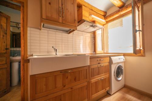 uma cozinha com um lavatório e uma máquina de lavar roupa em Apartamentos la Rambla Callizo em Montalbán
