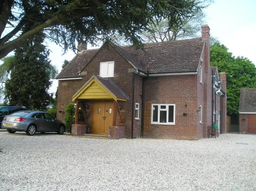 a brick house with a yellow door and a car at B&B Dorwyn Manor in Avebury