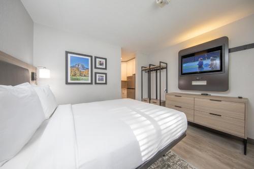 a bedroom with a white bed and a flat screen tv at The Jackson SouthTown in Jackson