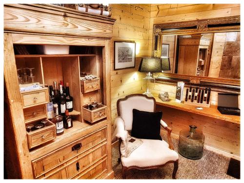 a room with a chair and a desk with wine bottles at La Grange du couvent B&B in Ribeauvillé