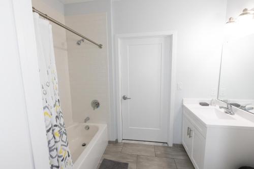 a white bathroom with a tub and a sink and a shower at Quaint Two-Bedroom Abode mins to NYC in Jersey City