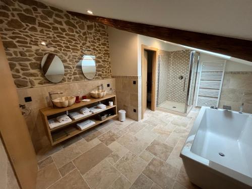 y baño con bañera, lavabo y espejo. en Domaine de la Calamande, en Grillon