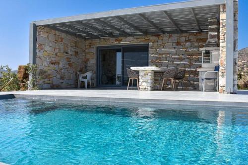 a patio with a table and chairs next to a pool at Drios Hillhouse in Drios