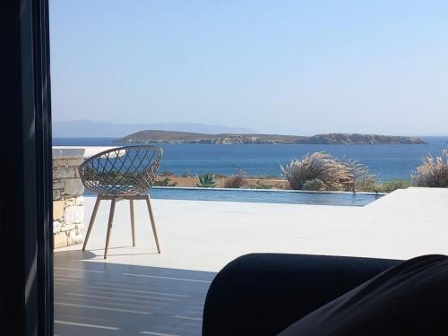 a chair sitting on a patio looking out at the water at Drios Hillhouse in Drios