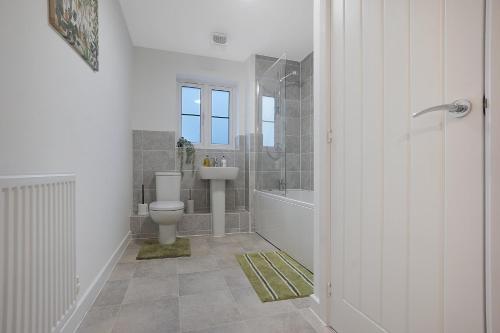 a bathroom with a toilet and a sink and a tub at Gravesend 2 Bed Apartment-2 minutes walk from shops, Restaurants and Motorway. Sleep upto 5 in Northfleet