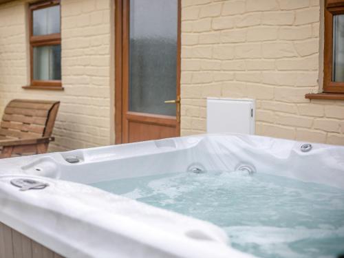 a large white bath tub in a room at 2 Bed in Aberystwyth TWLCT in Llanfihangel-y-creuddyn
